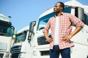A man standing by commercial vehicles. A lawyer can explain how negligence is established in a truck accident case.