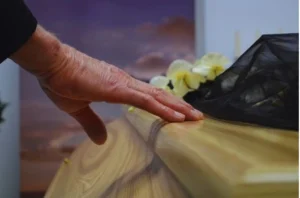 Hand touching a casket to show Skiber Law can help fight wrongful death cases